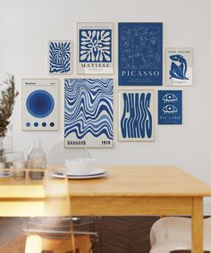 a dining room table with chairs and pictures on the wall