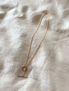 Dainty, lightweight 14k gold fill Figaro chain with gold fill toggle clasp closure. Wear it alone for a simple statement or layer it up for higher impact. Clasp can be worn in the front or back. Now with new clasp options: a smaller, minimal toggle clasp with ball ends or larger wreath style clasp. 16.75" length. Made in the USA 14k gold fill chain. Keep dry and wipe clean with a dry cloth. Designed and assembled in our DTLA studio. Everyday Toggle Necklace With Oval Link Paperclip Chain, Minimalist Gold Plated Toggle Necklace, Everyday Gold Lariat Necklace With Lobster Clasp, Classic Everyday Toggle Necklace With Link Shape, Classic Toggle Link Necklace For Everyday, Elegant Brass Toggle Clasp Necklace, Everyday Minimalist Necklace, Minimalist Toggle Necklace With Paperclip Chain, Gift Toggle Necklace With Delicate Chain