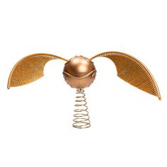 a golden metal object with two wings and a ball on it's head, against a white background