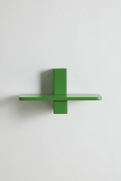 a green wall mounted object on the side of a white wall