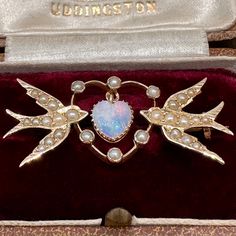 Here's one for appreciators of Victorian romantic jewellery.  Two swallows - symbolising faithfulness, as swallows mate for life - set with lustrous natural seed pearls carry in their beaks a heart within a heart.  The central heart-shaped solid Australian crystal opal dangles from a bale, its constant movement maximising the colour play.   This appealing brooch from about 1890 is stamped with an anchor and a fleece, the marks of the renowned Melbourne jewellers Duggin and Shappere, surrounding Romantic Jewellery, Crystal Opal, Antique Boxes, Yellow Gold Setting, Seed Pearl, Australian Opal, Opal Crystal, Antique Jewellery, Jewelry Art