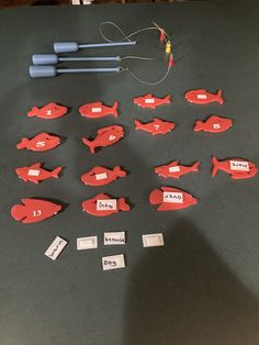 a group of red fish sitting on top of a table next to some blue markers