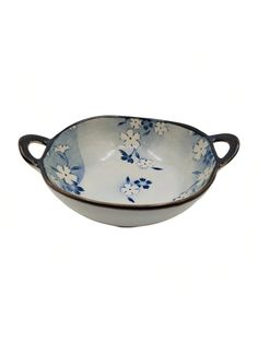 a blue and white bowl with flowers on the rim, sitting in front of a white background