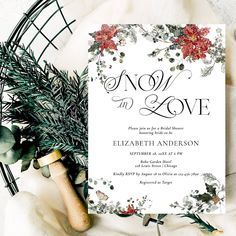 a white wedding card with red flowers and greenery