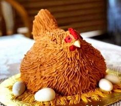 a cake shaped like a chicken sitting on top of a plate with eggs around it