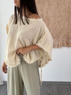 Embrace effortless summer style with our Cotton Dolman Sleeve Top. This blouse features distinctive batwing sleeves and a wide, off-shoulder neckline, crafted from soft linen for ultimate comfort. Perfect for both casual and dressy occasions, it adds a touch of bohemian chic to any outfit. A lovely gift for her, this top combines versatility with modern elegance. Key Features ✨ * Material: Soft, breathable organic cotton that offers luxurious comfort while being environmentally friendly. * Size: Summer Tops With Frayed Hem And Relaxed Fit, Summer Tops With Frayed Hem In Relaxed Fit, Summer Beach Blouse With Back Tassel Tie-up, Summer Tops With Frayed Hem For Day Out, Bohemian Cotton Blouse With Back Tassel Tie-up, Breezy Cotton Short Sleeve Blouse, Breezy Short Sleeve Cotton Blouse, Cotton Tops With Frayed Hem For Summer, Bohemian Beige Blouse For Vacation