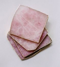 three pink marble coasters stacked on top of each other with gold trim around the edges