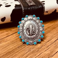 The Big Cactus Stretch Ring is a 2 round western stamped ring with a high polish textured western style concho Cactus placed at it's center. The ring features a western stamped design with small turquoise stones placed around the edge.  Flexible and adjustable ring cuff.   2 pendent Stamped Ring, Cowgirl Jewelry, Stamped Rings, Stretch Ring, Turquoise Stones, Western Jewelry, Stamp Design, The Ring, Adjustable Ring