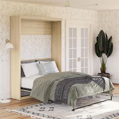 a large bed sitting on top of a wooden floor next to a white door and window