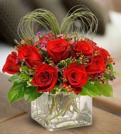 a vase filled with red roses on top of a table