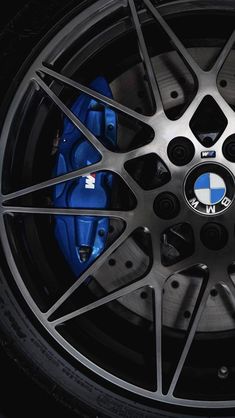 the wheel of a bmw car with blue brake pads on it's rims