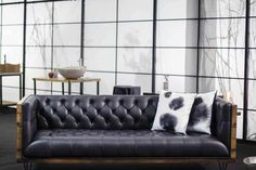 a black leather couch with some pillows on it