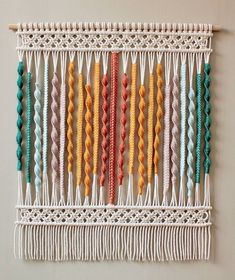 a wall hanging made out of macrame beads and yarn with different colors on it