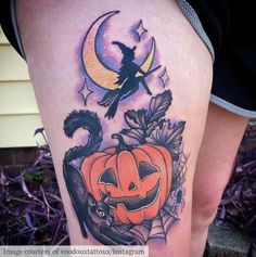 a woman's thigh with a halloween pumpkin and cat tattoo design on the leg