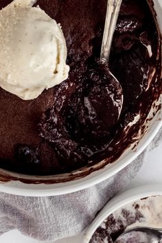 chocolate self - saucing pudding in a bowl with ice cream on top and spoon