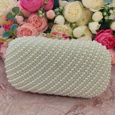 This luxurious encrusted pearl bridal clutch never fails to turn heads with its understated elegance and classic design. Adorned with varying sized ivory pearls and enhanced with a large creamy pearl clasp, this bridal clutch is the very picture of refinement. This elegant bridal clutch features rose gold trim, attachable chain and large enough for your phone. Complete your list of must-have wedding accessories with the ultimate bridal accessory to finish off your look and storing your wedding d Gold Pearl Evening Bag For Events, Elegant Pearl White Clutch For Events, Elegant Pearl White Clutch Evening Bag, Elegant Pearl White Evening Bag For Formal Occasions, Elegant Pearl White Rectangular Evening Bag, Pearl White Evening Bag With Pearl Handle, Pearl White Evening Bag With Pearl Handle For Events, Pearl White Clutch Evening Bag For Formal Occasions, White Clutch With Pearl Handle For Events