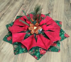 a red and green christmas ornament sitting on top of a wooden floor