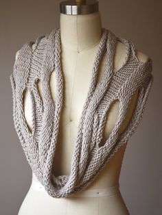 a white mannequin with a knitted scarf on it