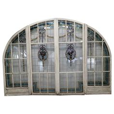 an arched window with decorative glass on the front and side panels, set against a white background