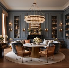 a living room filled with furniture and a chandelier above a round dining table