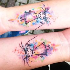 two people with matching tattoos on their arms, both have colorful ink splatters