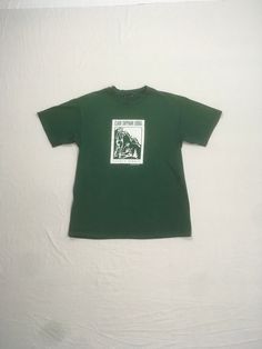 vintage 1990s t-shirt Clair Tapaan Lodge Donner Summit Established 1934 green tee w/white print image of 2 campers w/mountain peaks in the background good vintage condition w/some wear-small stain/paint spots-see photos no tag, cotton feel , single stitch fits like a xs/s-see below measures, lying flat, shoulder-18" chest-18" sleeve-7" length-26 1/2" Green Graphic Print T-shirt For Camping, Green T-shirt For Outdoor Activities, Pre-shrunk Green T-shirt For Camping, Green Crew Neck T-shirt For Outdoor Activities, Green Crew Neck T-shirt For Outdoor, Green Graphic Print Outdoor T-shirt, Outdoor Green T-shirt With Graphic Print, Green Graphic Print T-shirt For Outdoor, Green Graphic Tee For Outdoor Activities