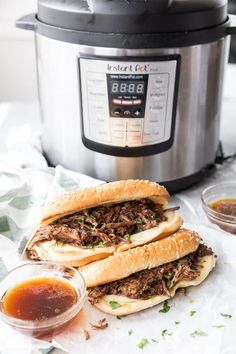 two pulled pork sandwiches in front of an instant pot