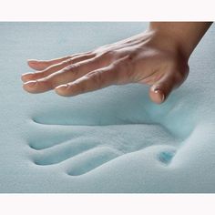 a person's hand reaching for something on top of a foam covered bed sheet