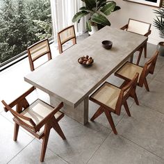 a dining room table with six chairs and a potted plant