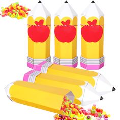 an image of some candy in the shape of pencils with apples on them and other candies