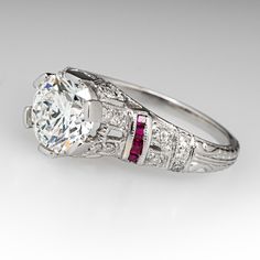 This beautiful contemporary Art Deco style platinum diamond and ruby accented mounting holds an IGI certified lab grown diamond that grades F in color and VS1 in clarity with an excellent cut grade. The ring is currently a size 7.25. EraGem lab diamond rings will arrive with an in-store certification as well as the IGI report and a lovely EraGem logo presentation box. Classic Gia Certified Diamond Ring With Lab-created Ruby, Gia Certified Classic Ruby Ring With Diamond Accents, Luxury White Diamond Ruby Ring, Luxury White Ruby Ring With Diamonds, White Ruby Ring With Vvs Clarity, White Gold Platinum Ruby Ring Round Cut, Luxury Diamond Ring With Lab-created Ruby Accents, Classic White Diamond Ruby Ring, Classic White Ruby Ring With Vvs Clarity