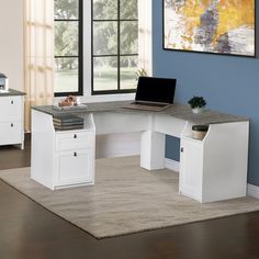 a computer desk with two drawers and a laptop on it in front of a window