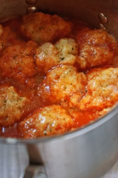 a pot filled with meatballs covered in sauce