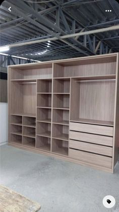 an empty room with wooden shelves and drawers