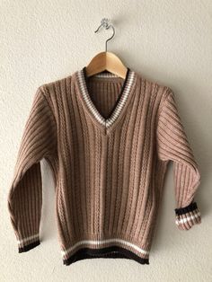 A fantastic 1960s sweater featuring a cable knit design and V neckline. In excellent condition!  No stains, snags etc. Would look amazing layered or by itself. No tags, but most likely will fit a range from 4T-5. As always, please see pictures of approx. measurements.    Feels to be an acrylic/wool blend~ +Why buy Vintage? Aside from owning something most likely is one of a kind; it is also a great opportunity for optimal recycling - a great way to not add to the mass overproduction, and to help Retro Long Sleeve Ribbed Sweater, Retro Ribbed Knit Sweater, Vintage V-neck Knit Sweater, Retro Cable Knit Sweater For Fall, Vintage Winter Sweater With Ribbed Cuffs, Vintage Knit Sweater With Ribbed Collar, Retro Brown Knit Sweater, Retro Long Sleeve Cable Knit Sweater, Brown Retro Knit Sweater