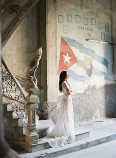 a woman in a white dress standing on some steps