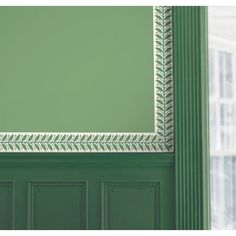 a green door with a white frame and decorative trim on the top part of it