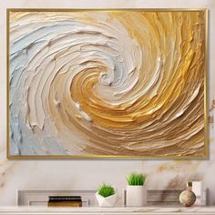 an abstract painting with gold and blue swirls on the wall next to a fireplace