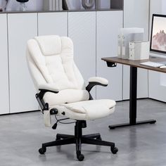 a white office chair sitting in front of a computer monitor