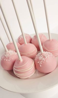 pink cake pops with white sprinkles on a plate