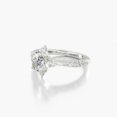 a white gold ring with an oval cut diamond and pave set diamonds around the band