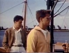 two men standing next to each other on a boat