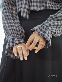 a woman wearing a black and white checkered shirt holding her hands together