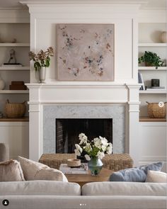 a living room filled with furniture and a painting on the wall above a fire place