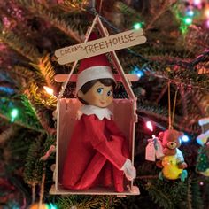 an ornament hanging from a christmas tree with the elf on it's back