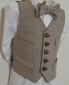 "This fine quality wool tweed vest is available in all sizes from toddler to youth.  It is made of 100% wool brown and ivory striped twill, and lined in dark brown 100% cotton.  It is designed as a  historical period style vest, with 5 natural leather buttons, 4 front welts, bottom pockets are functinal. Dry Clean Only. We now offer this very popular vest in black/ecru striped twill as well. Each vest is custom made to order, tailored to fit using customer supplied measurements, and muslin fitti Fitted Brown Wool Vest, Brown Buttoned Vest For Formal Occasions, Brown Formal Vest With Buttons, Formal Brown Vest With Buttons, Fitted Brown Winter Vest, Tailored Brown Vest With Buttons, Brown Wool Vest For Tailoring, Tailored Brown Wool Vest, Brown Tweed Vest For Winter