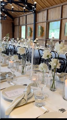 the tables are set with white flowers and candles