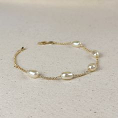 Indulge in the timeless beauty and sophistication of our 18k Gold Filled Spaced Baroque Pearl Bracelet. The perfect blend of elegance and delicacy, this classic piece exudes a luxurious charm that will elevate any outfit. Add a touch of opulence to your wardrobe and captivate with every turn of your wrist. Metal: 18k Gold Filled Width: 10mm Simulated Baroque Pearl Beads Size: 6.5 + 1 inch adjustment. Hypoallergenic Water-resistant Handcrafted in Brazil Classic White Gold Pearl Bracelet With Oyster Clasp, Classic White Gold Pearl Bracelet With Oyster Details, Elegant Pearl Chain Jewelry, Elegant Formal Rose Gold Bracelet, Luxury Pearl Bracelets For Anniversary, Luxury Pearl Bracelets For Wedding, Elegant Wedding Bracelets With Pearl Drop, Classic Gold-plated Bracelet With Oyster Detail, Luxury Gold Bracelets With Elegant Design