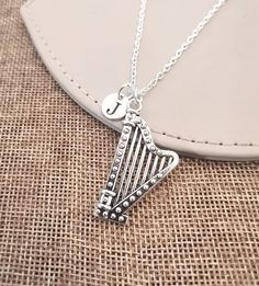 a silver necklace with a harp on it