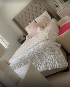 a bed with white sheets and pillows on top of it